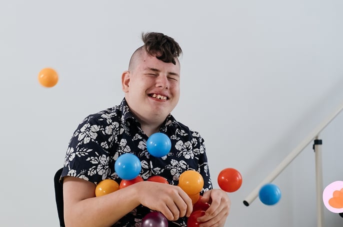 Young boy playing with balls and smiling