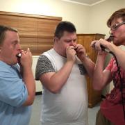 three men playing harmonicas