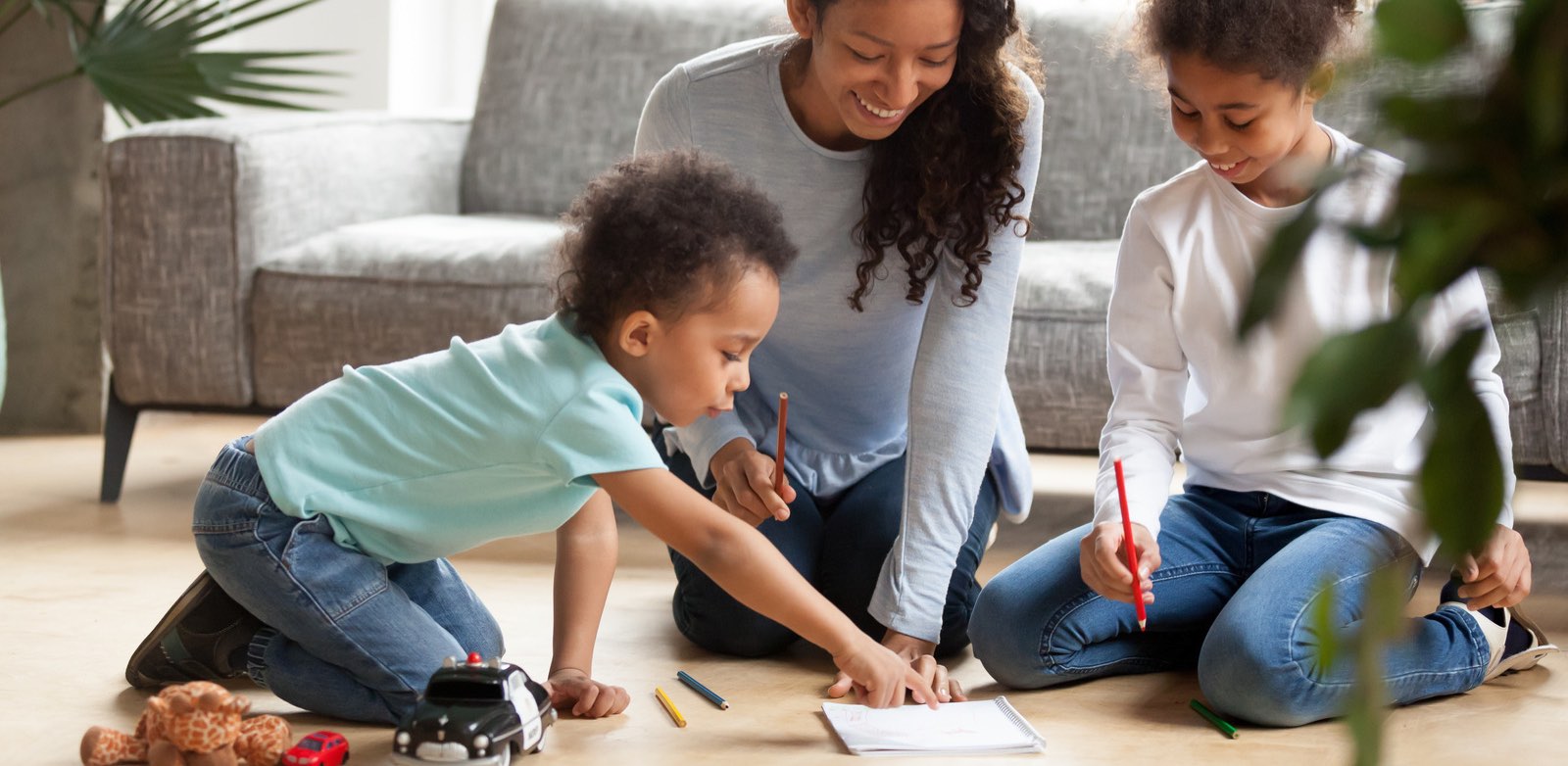 Mother and children sitting on floor writing a social story