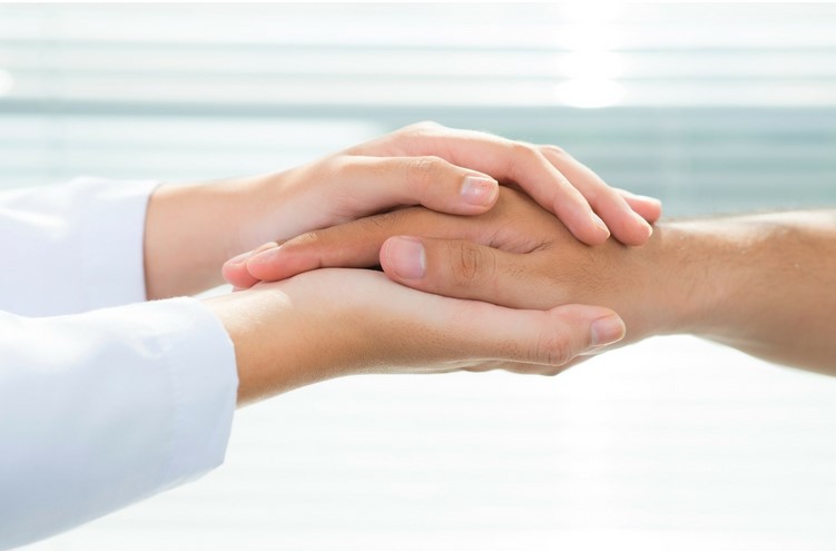 closeup of a person's hands holding another's in support