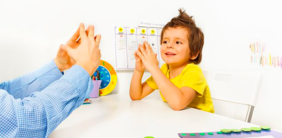 Young boy in a bright yellow shirt in an OT session