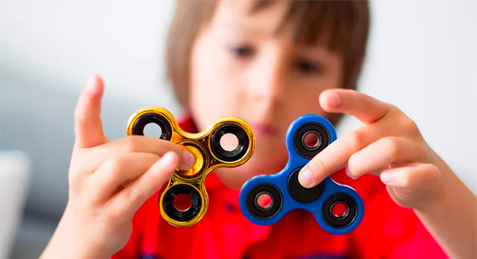 Boy in red tshirt playing with 2 fidget spinners