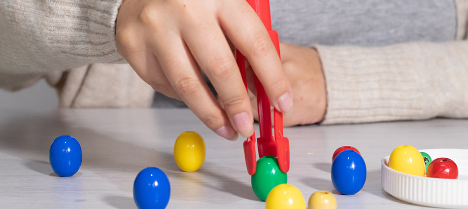 Person picking up beads in an therapy session
