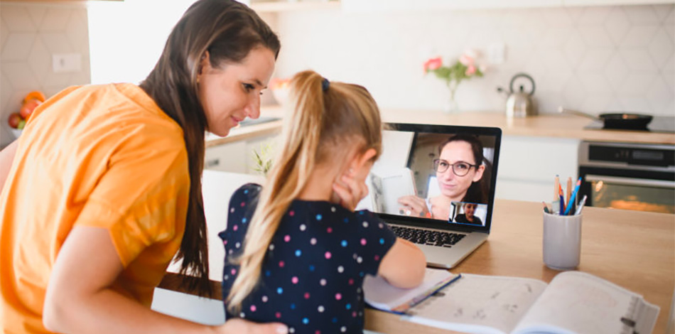 A parent and child are using a laptop for online therapy