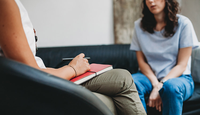 A young woman sitting on a couch receiving counselling