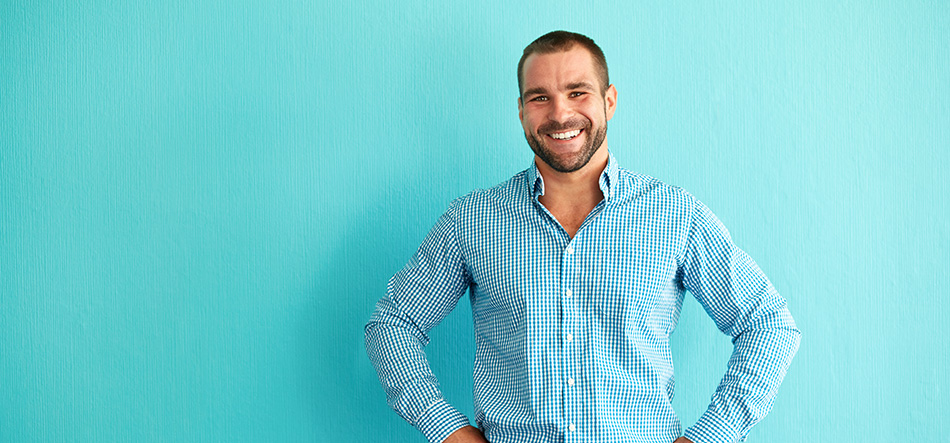 Man standing smiling with his hands on his hips