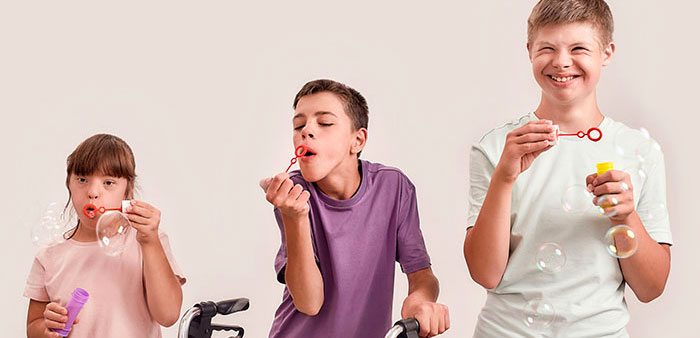3 children with cerebral palsy blowing bubbles