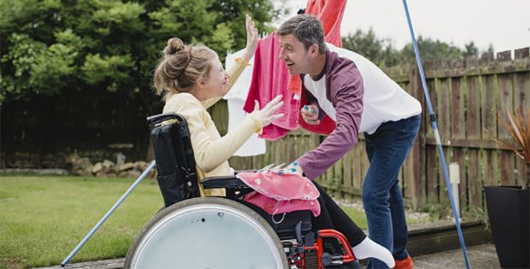 Carer with young girl in wheelchair