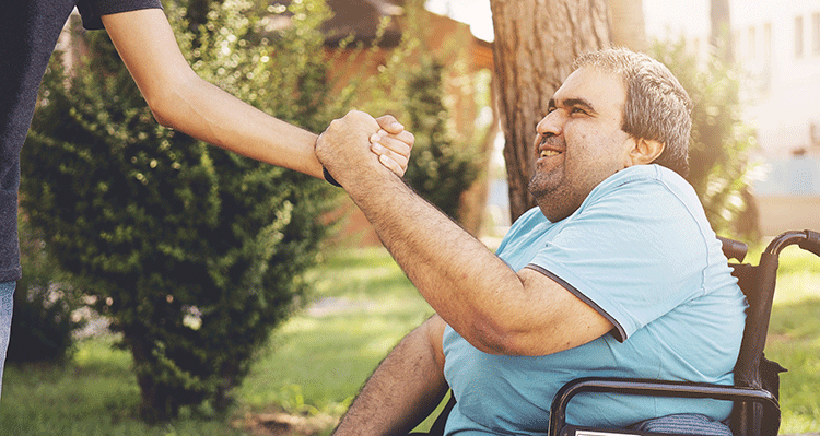 man in wheelchair shaking hands