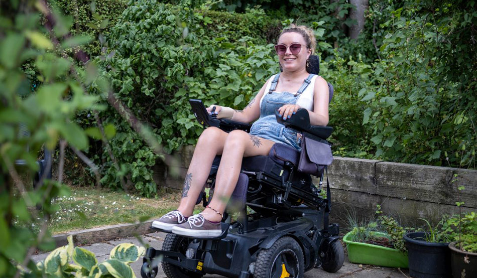 Woman in garden seated in powered wheelchair