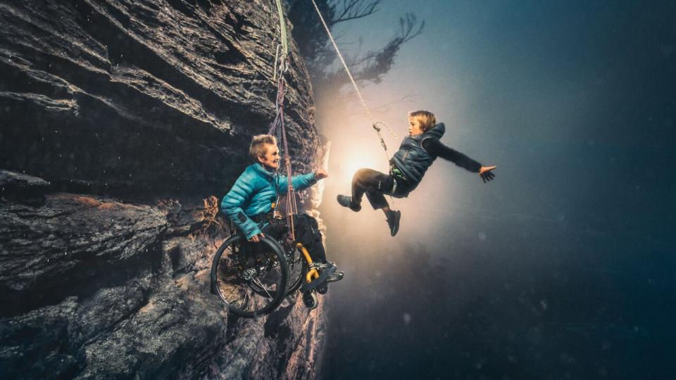 portrait of SJ and her son hanging from a cliff.