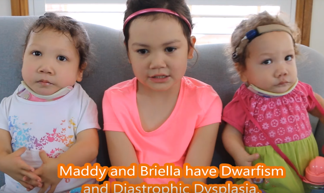 Maddy and her sisters sitting on a couch