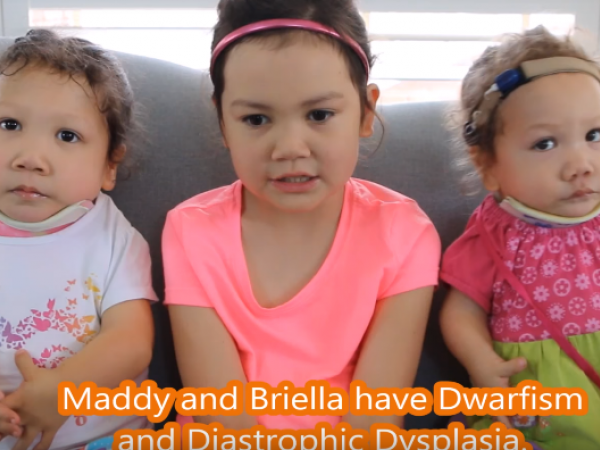 Maddy and her sisters sitting on a couch