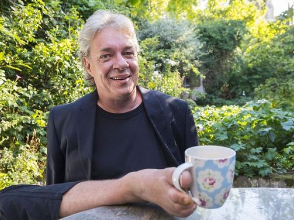 Brett Nielsen holding a coffee mug in his toes.