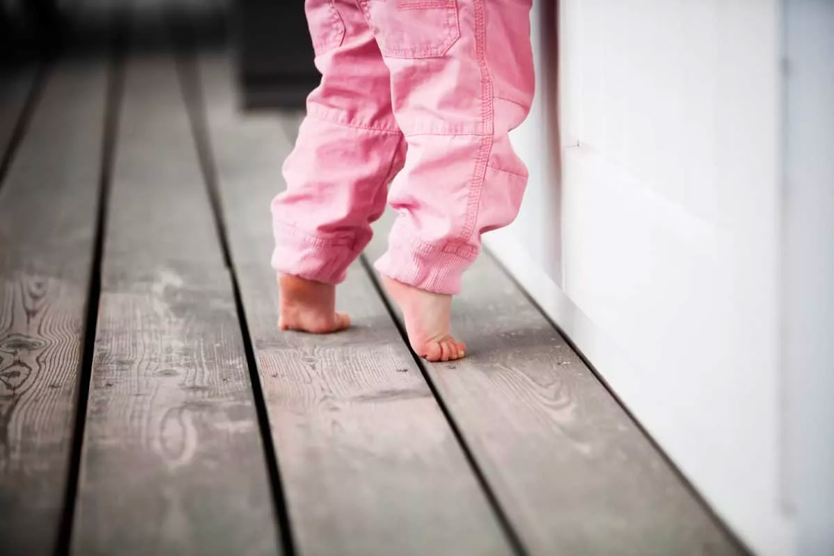 Young child toe walking wearring pink trousers